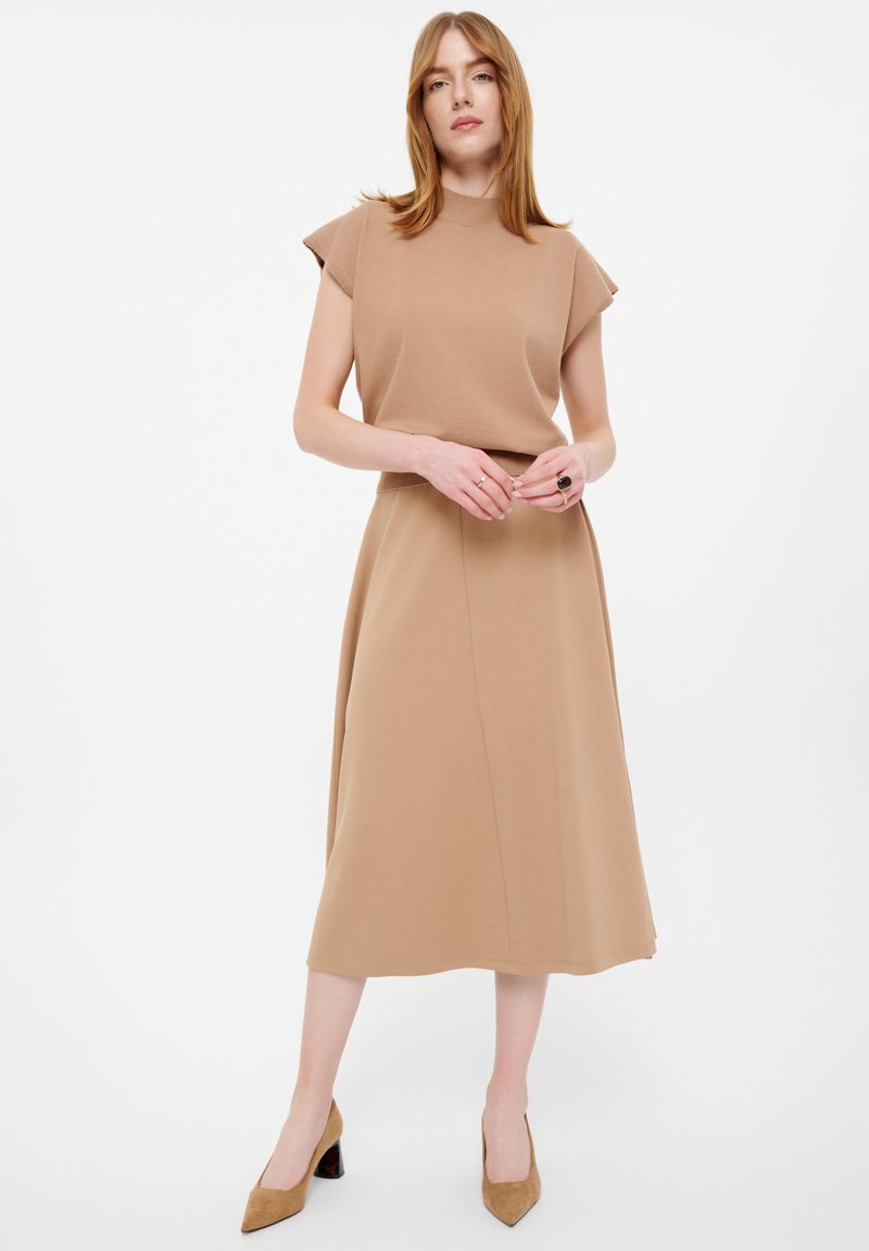 Beiges Kleid mit kurzen, strukturierten Ärmeln, einem hohen Halsauschnitt und einem fließenden A-Linien-Rock. Der Stoff hat eine glatte Textur.