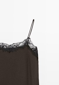 Black sleeveless camisole with lace trim along the neckline and thin adjustable shoulder straps on a white background.