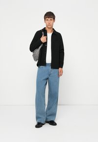 Black button-up shirt, white t-shirt underneath, blue wide-leg jeans, black shoes, and gray shoulder bag. Simple design, casual fit.