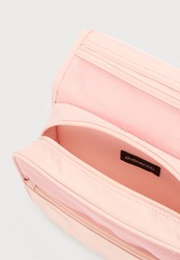 Ροζ τσαντάκι με φερμουάρ, με λείο εξωτερικό, τσέπη από δίχτυ και δεύτερο διαμέρισμα με μαλακή, αντίθετη εσωτερική επένδυση. Ορατή ετικέτα με το λογότυπο.