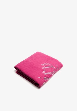 Couverture fuchsia en matériau doux, avec un design plié et des motifs floraux cloutés en argent sur un côté.