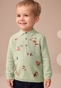 Maglione verde chiaro con collo a camicia, decorato con animali della foresta, foglie e funghi ricamati. Bottoni marroni sul collo.