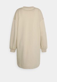 Beige Oversize-Sweatshirtkleid mit langen, puffigen Ärmeln und rundem Halsausschnitt. Schlichte Textur ohne Muster oder zusätzliche Details.