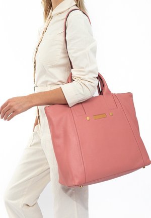 Sac fourre-tout en cuir rose avec deux poignées, une finition texturée et des accents métalliques dorés. Le sac est orné d'une bande horizontale cloutée.