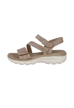 Sandalia casual beige con tres tiras ajustables de velcro y una suela blanca gruesa y texturizada diseñada para comodidad y soporte.