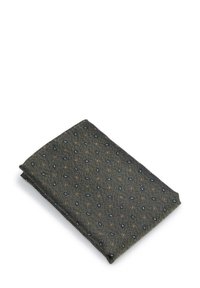 Katoenen pochet, donker groen met een gestructureerd patroon van kleine marineblauwe druppelvormige motieven en rode vierkante accenten. Netjes gevouwen.