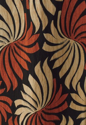 Textiel met een zwarte achtergrond en gedurfde, draaiende patronen in rood en beige, met een mix van bloem- en abstracte ontwerpen.