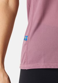 Purple athletic shirt with a textured pattern, featuring a blue and yellow flag accent near the hem. Designed for active wear.