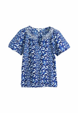 Kék rövid ujjú blúz fehér, absztrakt, spirális mintával és ráncolt nyakkivágással, bő szabású, könnyű anyagból készült.