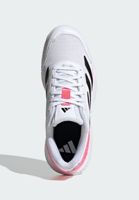 Chaussure de sport blanche avec des rayures noires, des accents roses, des lacets blancs et le logo Adidas sur la languette et la semelle intérieure, vue de dessus.