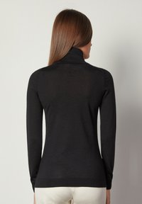 Schwarzer Rollkragenpullover aus glattem Strickstoff, eng anliegendes Design mit langen Ärmeln und gerippten Akzenten am Kragen und Saum.