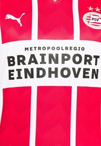 Maillot de sport rouge et blanc à rayures horizontales, avec un logo Puma, et le texte "METROPOOLREGIO BRAINPORT EINDHOVEN" en gras noir.