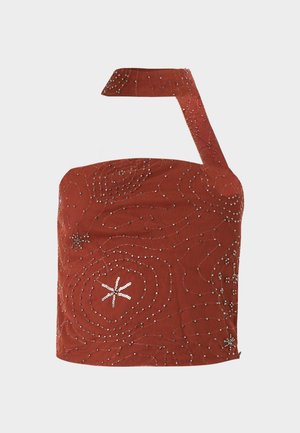 Top court asymétrique couleur rouille avec des décorations en perles argentées formant des motifs abstraits et étoilés sur un tissu texturé.