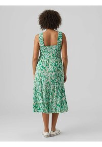 Zelené midi šaty se vzorem, s volánkovými ramínky, smockovaným živůtkem a vrstvenou sukní. Vyrobené z lehké látky s odvážným abstraktním designem.