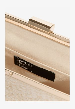 Metallisk guldfarvet clutch med en struktureret hvid yderside. Indersiden har blødt beige stof og en sort mærkat med teksten "friends like these...".