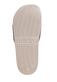 Suela de zapato Adidas, color crema, con un patrón de espiga para tracción, con el logo de la marca "adidas" grabado a lo largo del costado.