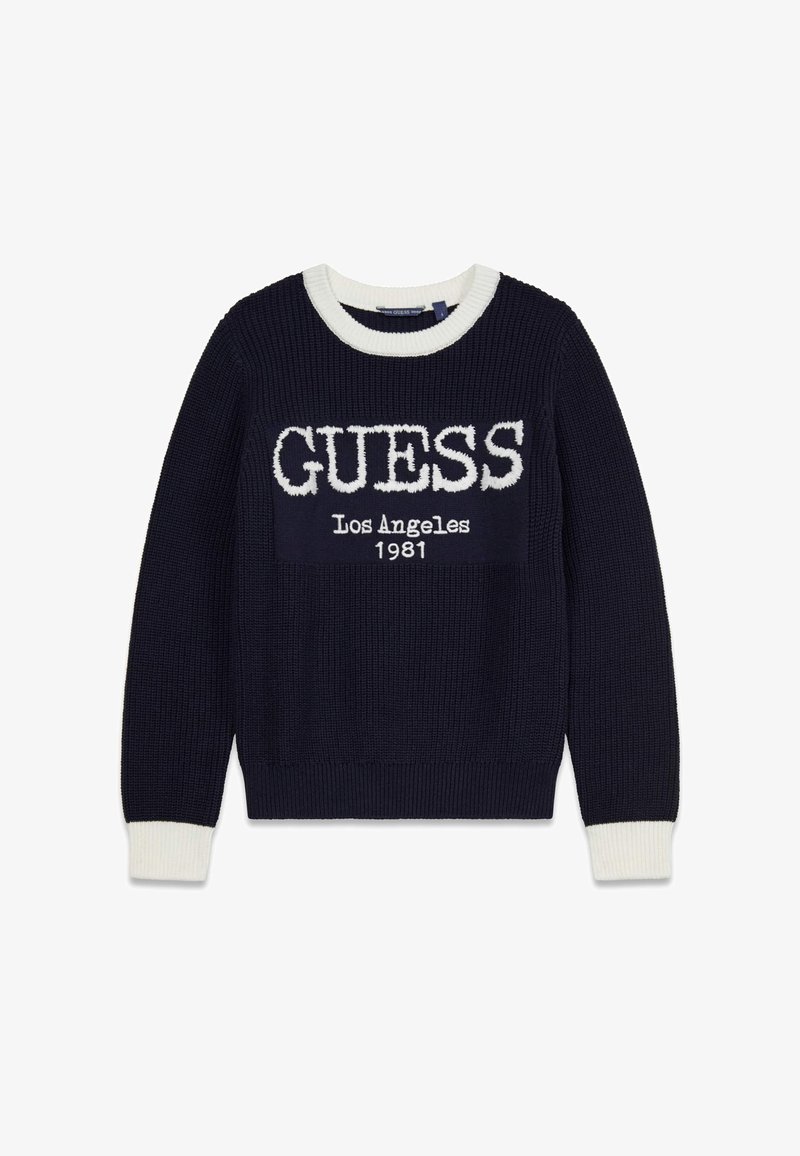 Pull en tricot bleu marine avec accents côtelés blancs et col rond. Présente l'inscription "GUESS Los Angeles 1981" en lettres blanches audacieuses sur le devant.