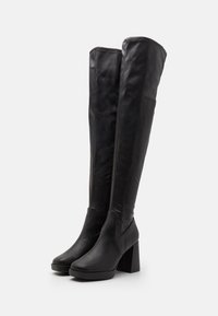 Svart över knäna-stövlar i slätt läder, med en fyllig klack och en slank, figursydd design utan synlig hårdvara.