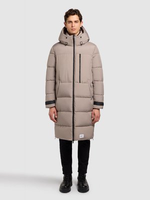 Valge beež vektrumine talvejope, millel on kapuuts, esiosal tõmblukk ja küljetaskud. Valmistatud tikandiga kangast, millel on tumedad äärised.