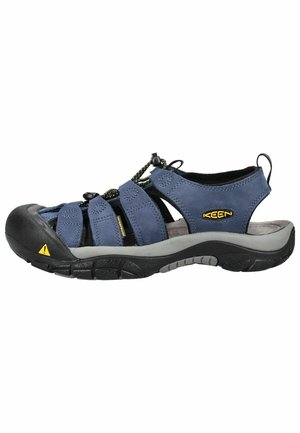 Sandalia de hombre azul impermeable para exteriores con puntera cerrada, cordón elástico ajustable, entresuela gris y suela negra resistente.