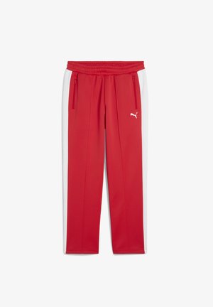 Red athletic pants with white side panels, elastic waistband, and zipper pockets. Features Puma logo in white on front. Made of smooth fabric.
