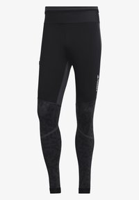 Black athletic leggings with a fitted design, featuring textured panels and stripes. Made from stretch fabric for comfort and flexibility.