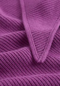 Fialová pletená látka s rebrovanou textúrou a diagonálnym švom. Materiál pôsobí mäkko a flexibilne s rovnomernou farbou.