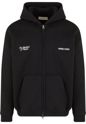 Melnas kokvilnas zip-up kapuce. Tai ir priekšējais kabata, ribota aproce un divas baltas izšūtas frāzes uz krūtīm.