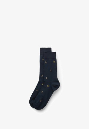 Navy blue socks made of soft material, featuring gold patterns of stars and boots throughout. Smooth texture, standard ankle length.