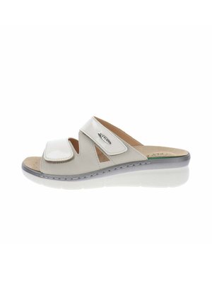 Sandalia ortopédica blanca con puntera abierta, dos correas ajustables de velcro y una suela acolchada ligeramente elevada para mayor comodidad y soporte.