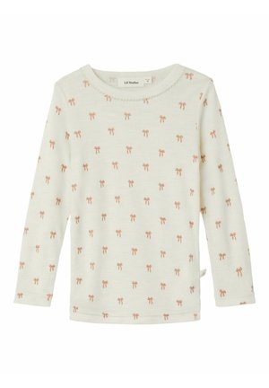 Chemise à manches longues de couleur crème en tissu doux, ornée d'un motif répété de nœuds roses et d'un col rond avec une bordure festonnée.