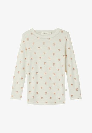 Majica dugih rukava boje krem sa mekanim materijalom, sa ponovljenim uzorkom ružičastih mašnica i okruglim izrezom sa valovitim rubom.