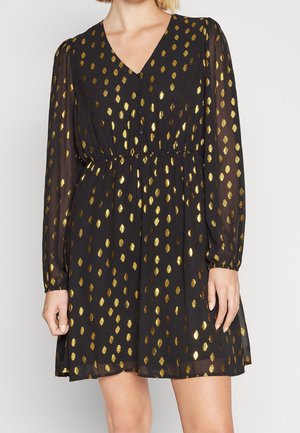 Vestido negro con mangas largas transparentes, que presenta acentos en patrón de diamante dorado, escote en pico y una cintura fruncida. Cierre de botones en el frente.