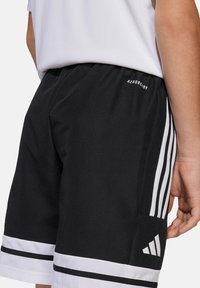 Zwarte sportshorts met witte zijstrepen, witte zoomaccenten en een AEROREADY-logo. Gemaakt van vochtregulerend materiaal.
