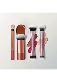 Fire Real Techniques-sminkekoster med prøver av brun, rosa, beige og lysebrun foundation og pudder på en lys bakgrunn.