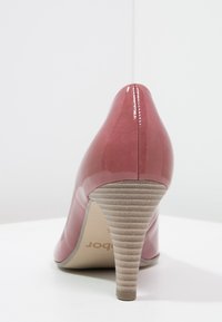Chaussure à talon haut en cuir verni rose avec un bout pointu, un talon beige texturé et une finition lisse, mettant en valeur un design épuré.