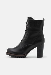 Sort læder ankelstøvle med rund tå, snøredesign, sølvfarvet hardware og hæl med tekstureret blok. Har en blød indvendig foring.