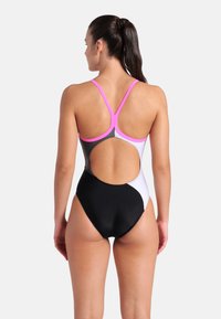 Costume da bagno intero con schienale scoperto, caratterizzato da spalline rosa, pannelli bianchi e neri e un tessuto liscio ed elastico.
