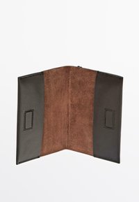 Portafoglio marrone in suede con dettagli in pelle nera, caratterizzato da un design bifold. Texture liscia sulla pelle e texture morbida e pelosa sul suede.