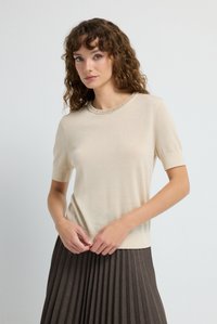 Hellbeiger Pullover mit kurzen Ärmeln und rundem Halsausschnitt, verziert mit einer Perlenborte. Glatte Textur mit einer leicht taillierten Silhouette.