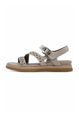 Grå ruskindssandaler med flad sål, brede krydsstropper, cirkulære udskæringer og spænde lukning på siden. Gummiydersål for godt greb.