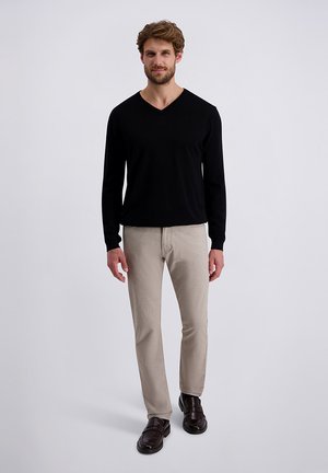 Zwart langermig V-hals shirt gecombineerd met lichtbeige broek en donkerbruine schoenen. Eenvoudig ontwerp, gladde textuur en neutrale kleuren.