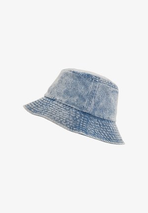 Lyseblå denim bøjlehat med synlige sømme og en blød, tekstureret skygge, der er vinklet mod højre på en hvid baggrund.