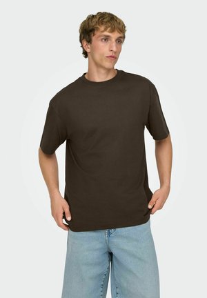 Ciemnobrązowy bawełniany t-shirt z okrągłym dekoltem i krótkimi rękawami, w zestawie z jasnoniebieskimi denimowymi szortami. Gładka faktura, casualowy krój.