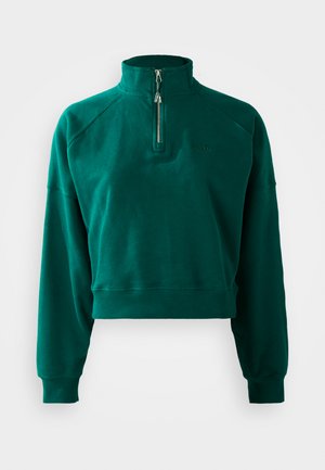 Zelený oversize sveter s krátkym strihom, polozipsovým golierom, prúžkovanými manžetami a jemnou textúrou. Vyšitá značka na hrudi.