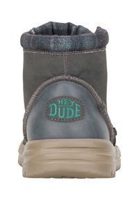 Stivale alla caviglia grigio con un morbido risvolto, suola in gomma e logo verde "HEY DUDE". Presenta cuciture lungo le cuciture e un materiale superiore testurizzato.