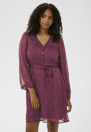 Lilla kleit lehepildiga, pikki silueteeriva õhukeste varrukatega, V-kaelusega, nööbikinnitusega ja taljepäraga, mis loob vormitud silueti.