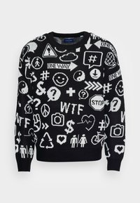Maglione nero a maglia con simboli grafici e testo bianchi, inclusi emoji, frecce e loghi. Collo a giro e polsini a coste.