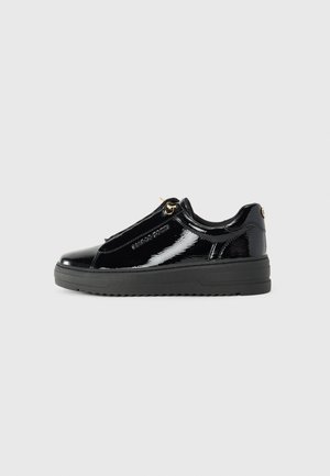 Baskets basses en cuir verni noir avec une semelle épaisse en caoutchouc, œillets dorés, fermeture éclair latérale et logo de la marque discret sur le côté.