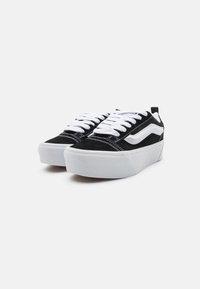 Mustad musta lõngaga madalad sneakers valgete aktsentidega, tugev valge tallaga, ümmarguste paelte ja õmmeldud disainiga.